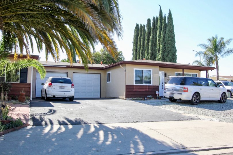 A sunny day in the area of San Marcos Manor, vehicles, palm tree, garage, parking lot, condo