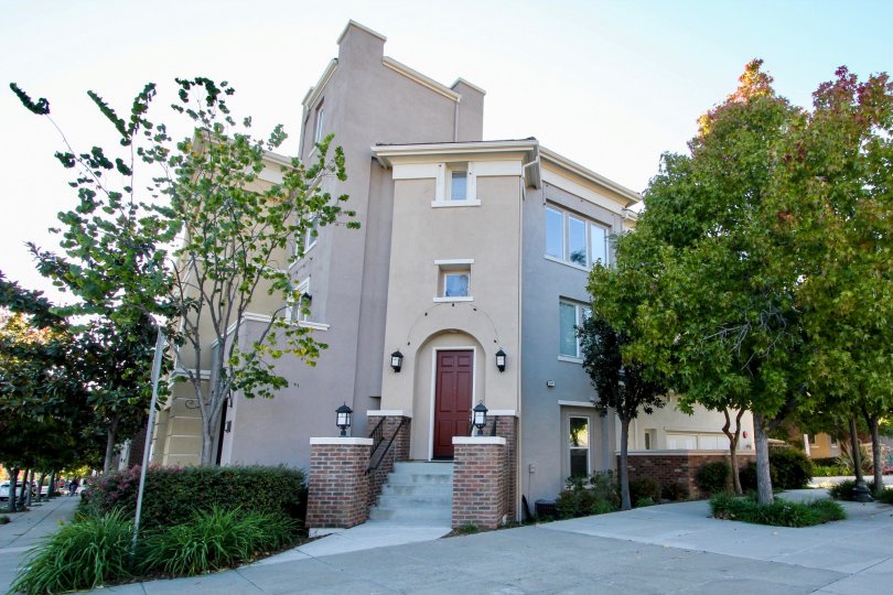 Four story residence with two large brick pillars & trees in Village Square in San Marcos CA