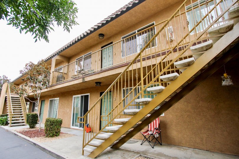 A view of the exterior of the San Remos Villas apartments showing exterior stairs, sliders, and a portion of the tiled roof.