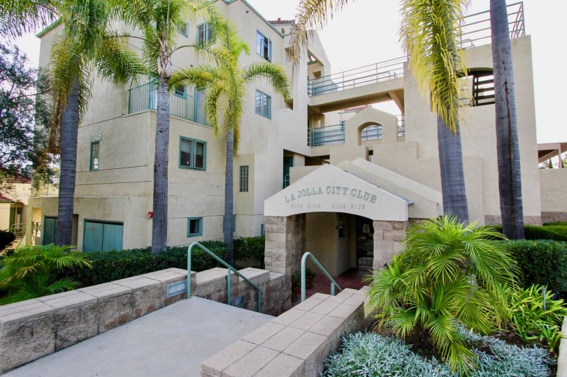 Entrance view of the building with trees and plants in La Jolla City Club