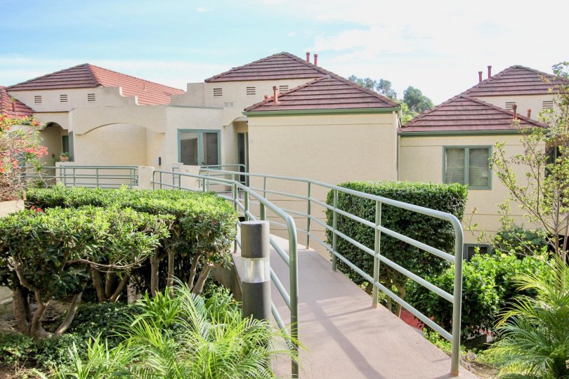 Raised walkway terrace overlooking housing units and professional landscaping at La Jolla City Club in University City, CA