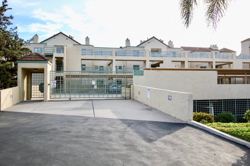 Entrance of the building with Blue gate with trees and plants surrounding in La Jolla City Club