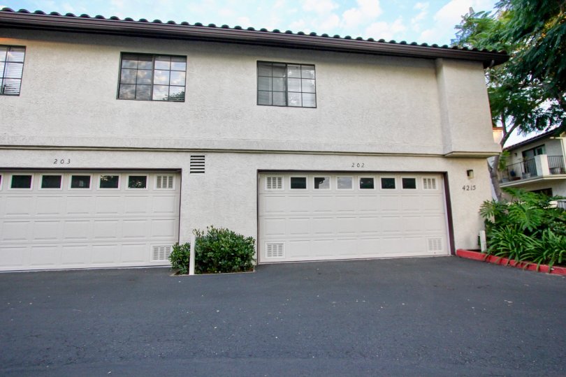 Tan garage doors in the Las Palmas community of University City, with a black driveway