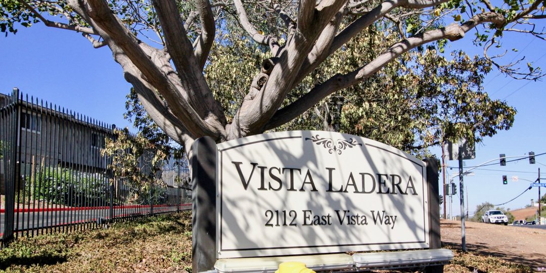 An elegant sign next to a tree at the Vista Ladera.