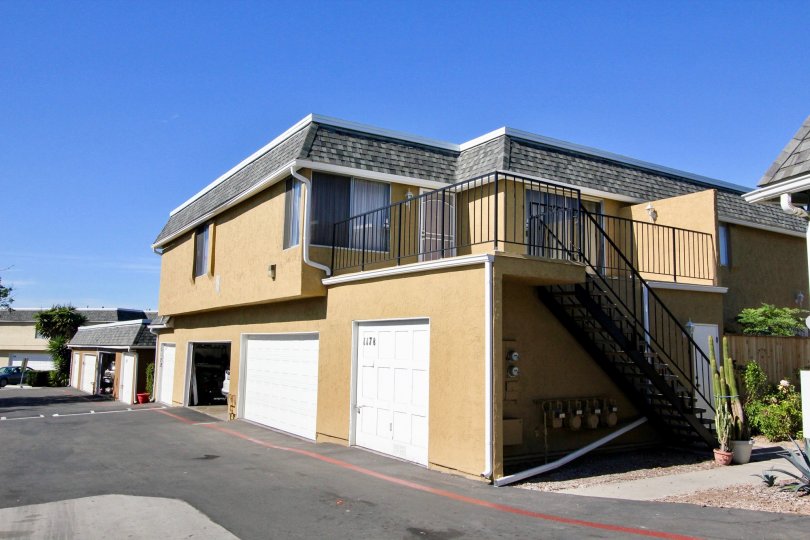 Brown building with white garage doors and driveway at Vista Park Villas in Vista CA